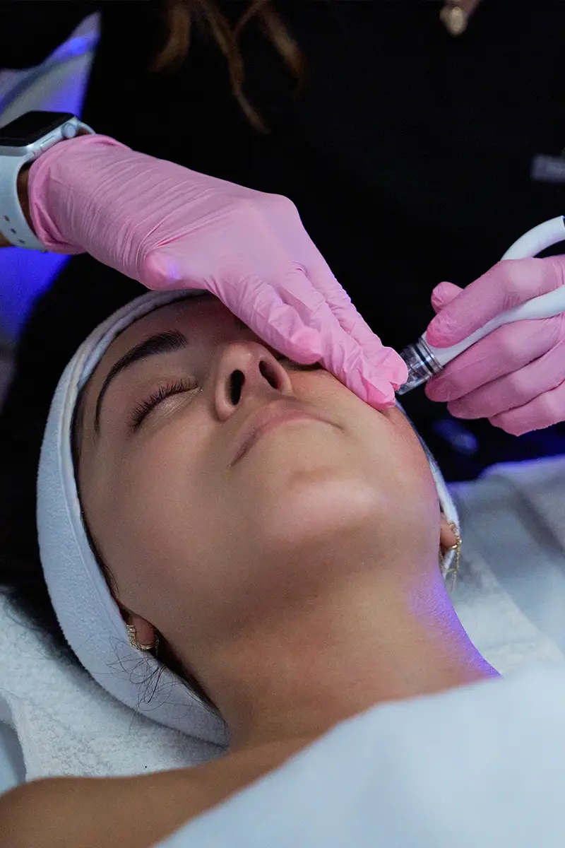 Young woman receiving a DiamondGlow facial treatment at HTB