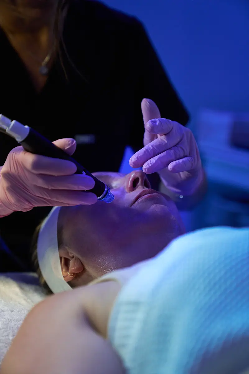 A young woman receiving a Hydrafacial treatment at HTB