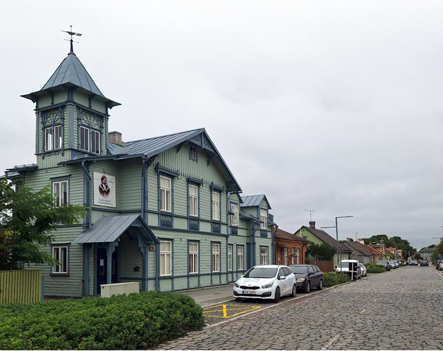 A building with a tower and cars parked on a streetAI-generated content may be incorrect.