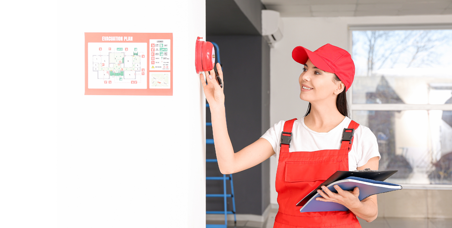 Eine Frau führt eine Wartung eines Feuermelders durch