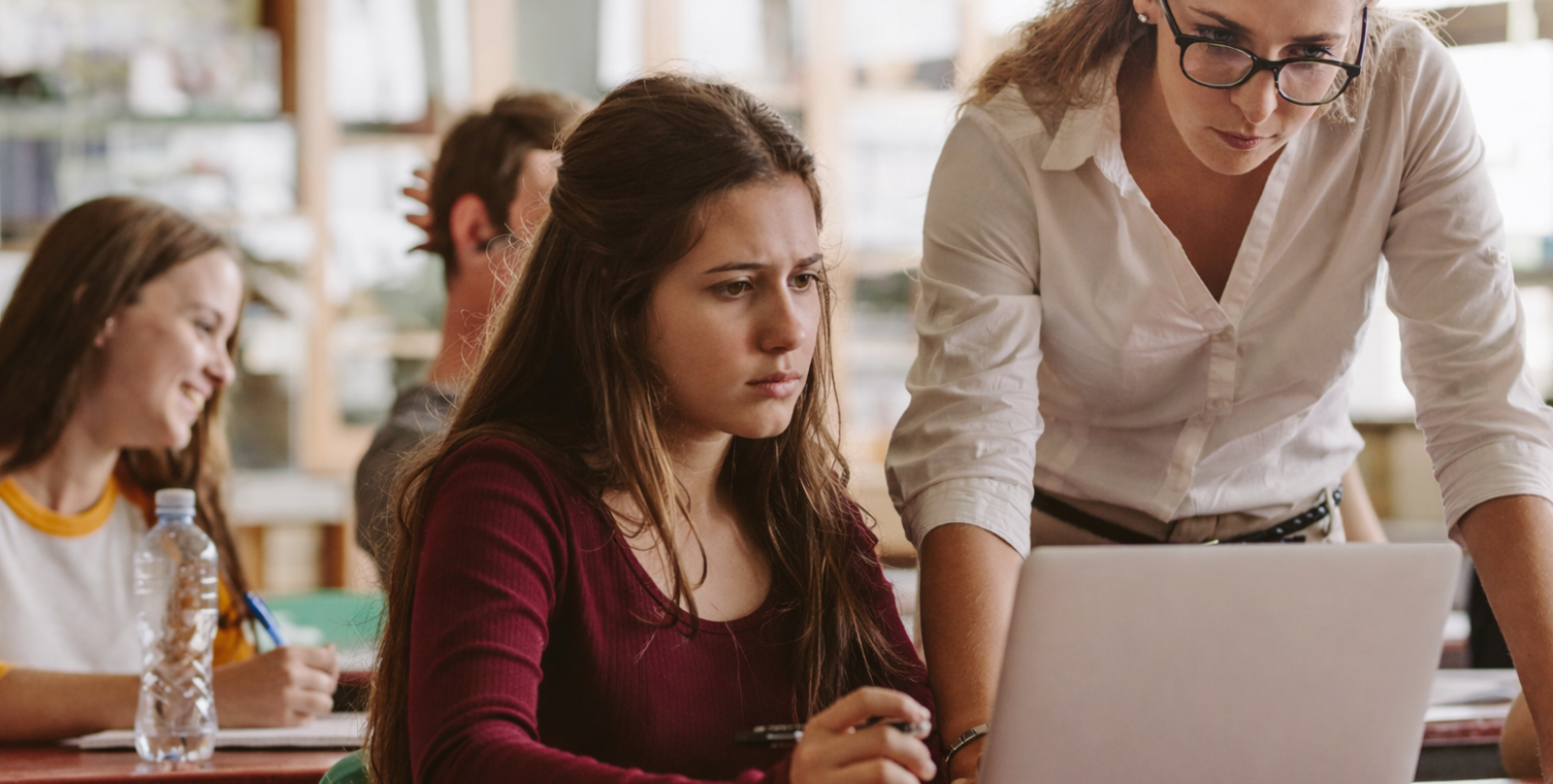 Lehrerin und Schülerin vor einem Laptop