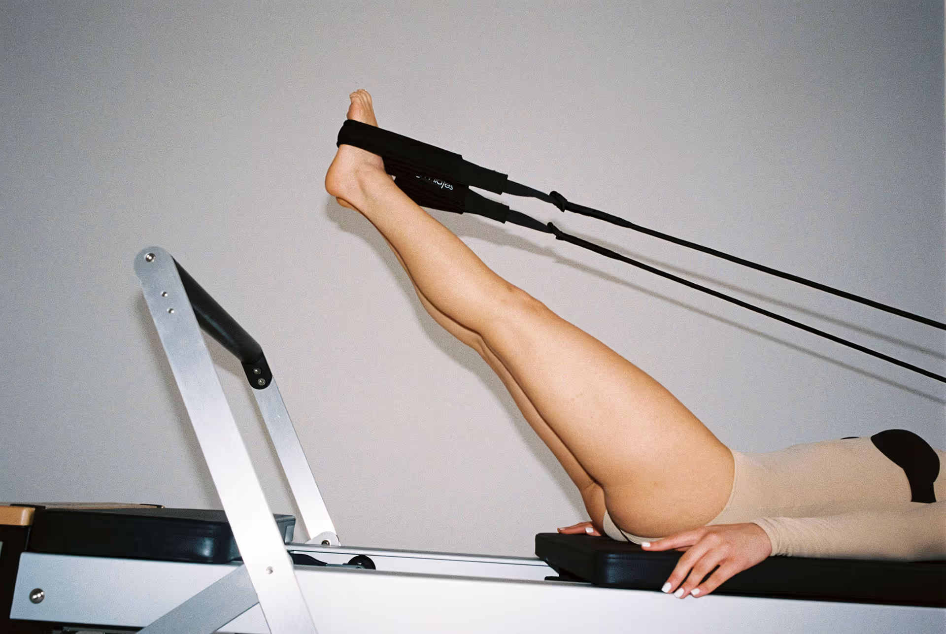 Frau trainiert auf einem Pilates Reformer Gerät