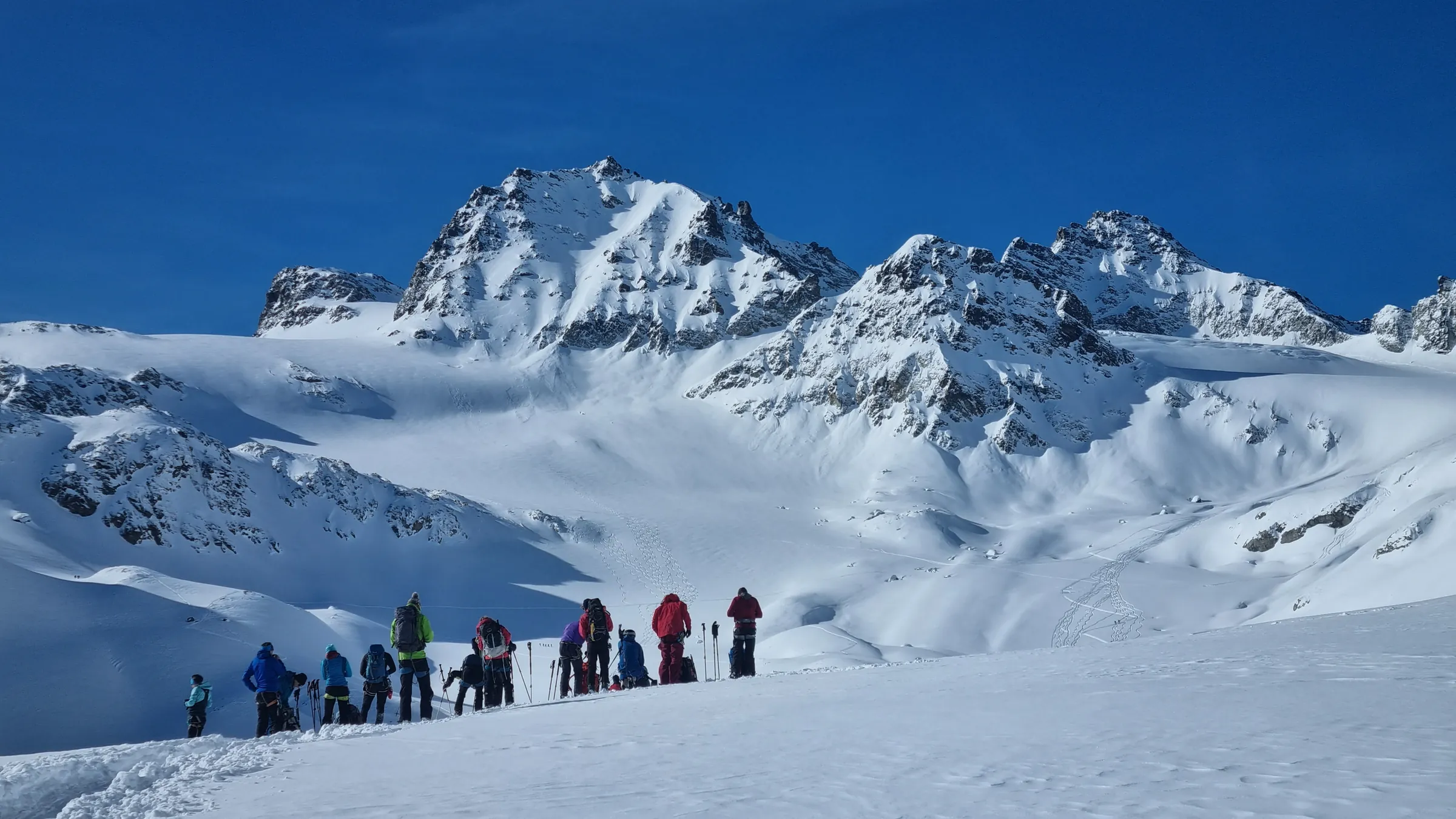 Group of ski tourers skinning toward snowy peaks in the Silvretta Alps