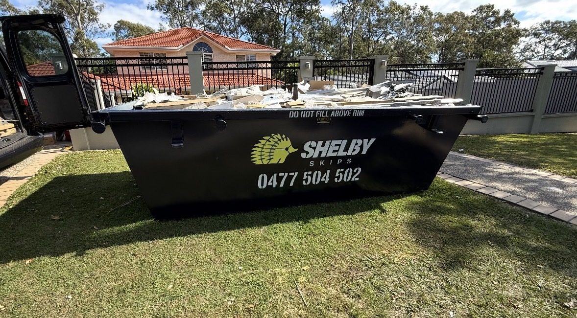 A Shelby Skips bin of foam board and cardboard on a front lawn