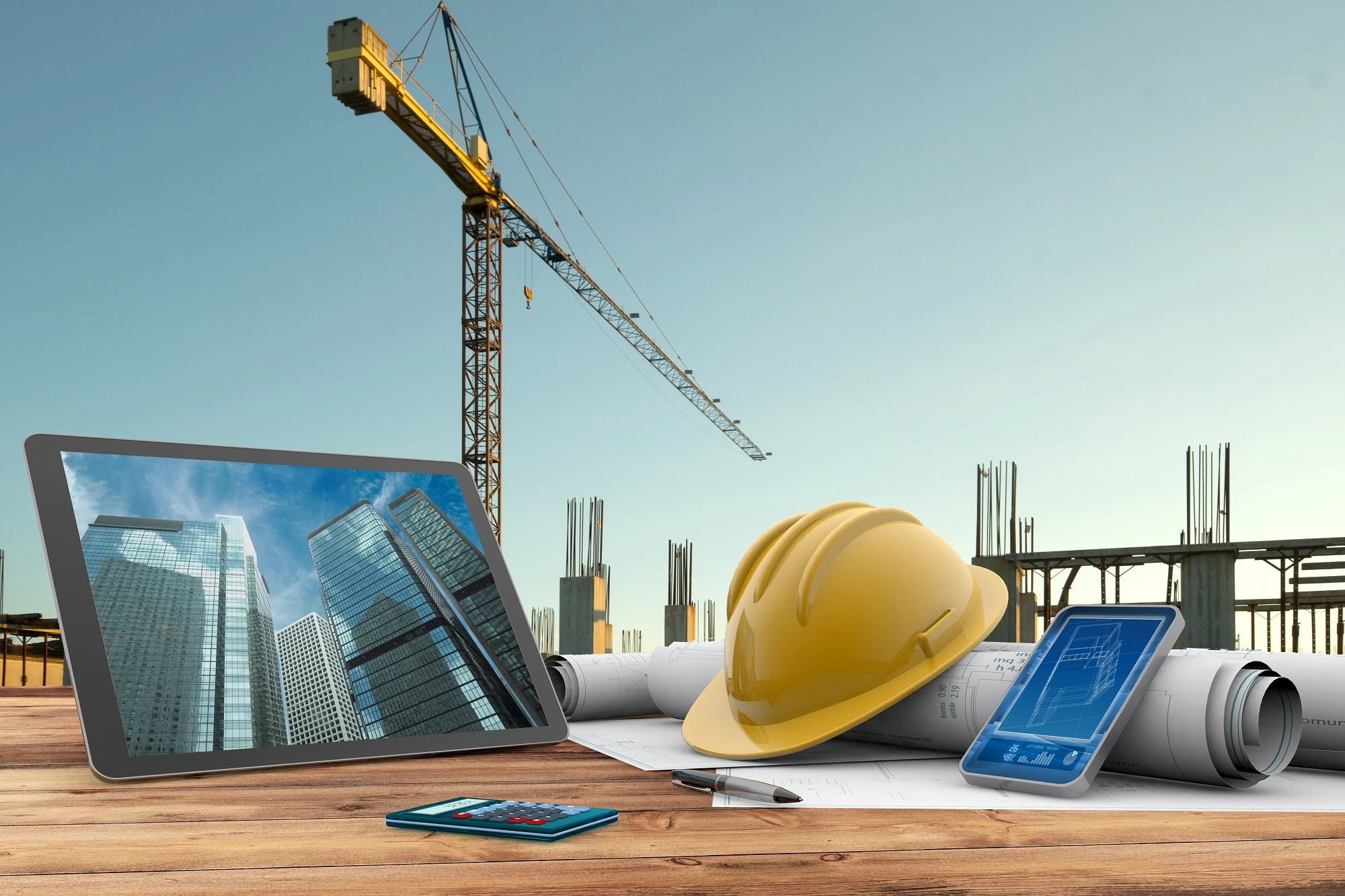 Commercial construction site with yellow safety helmet, building plans, tablet showing skyscrapers, and crane—Build Solutions Los Angeles general contractor