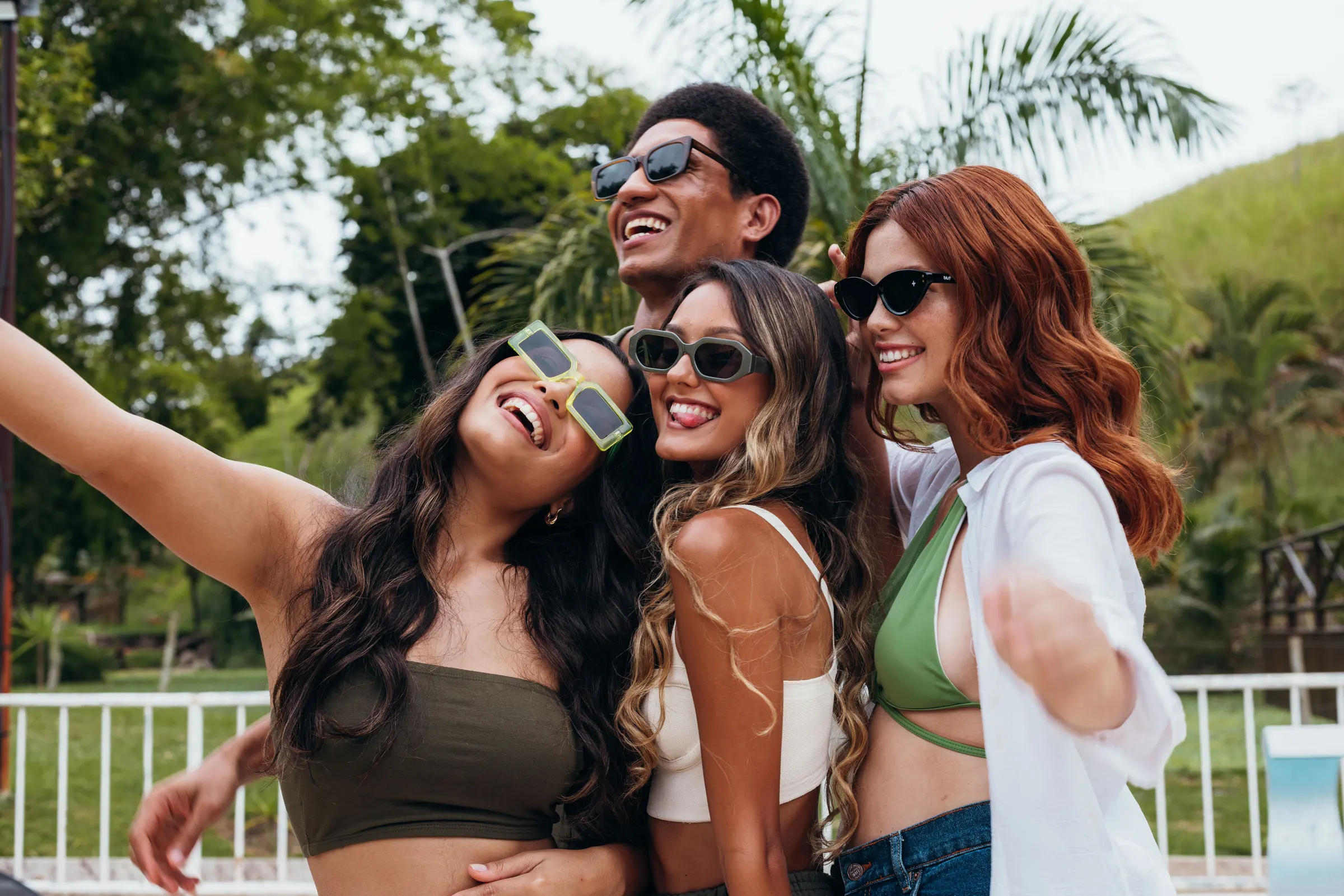 A group of friends in sunglasses laughing together