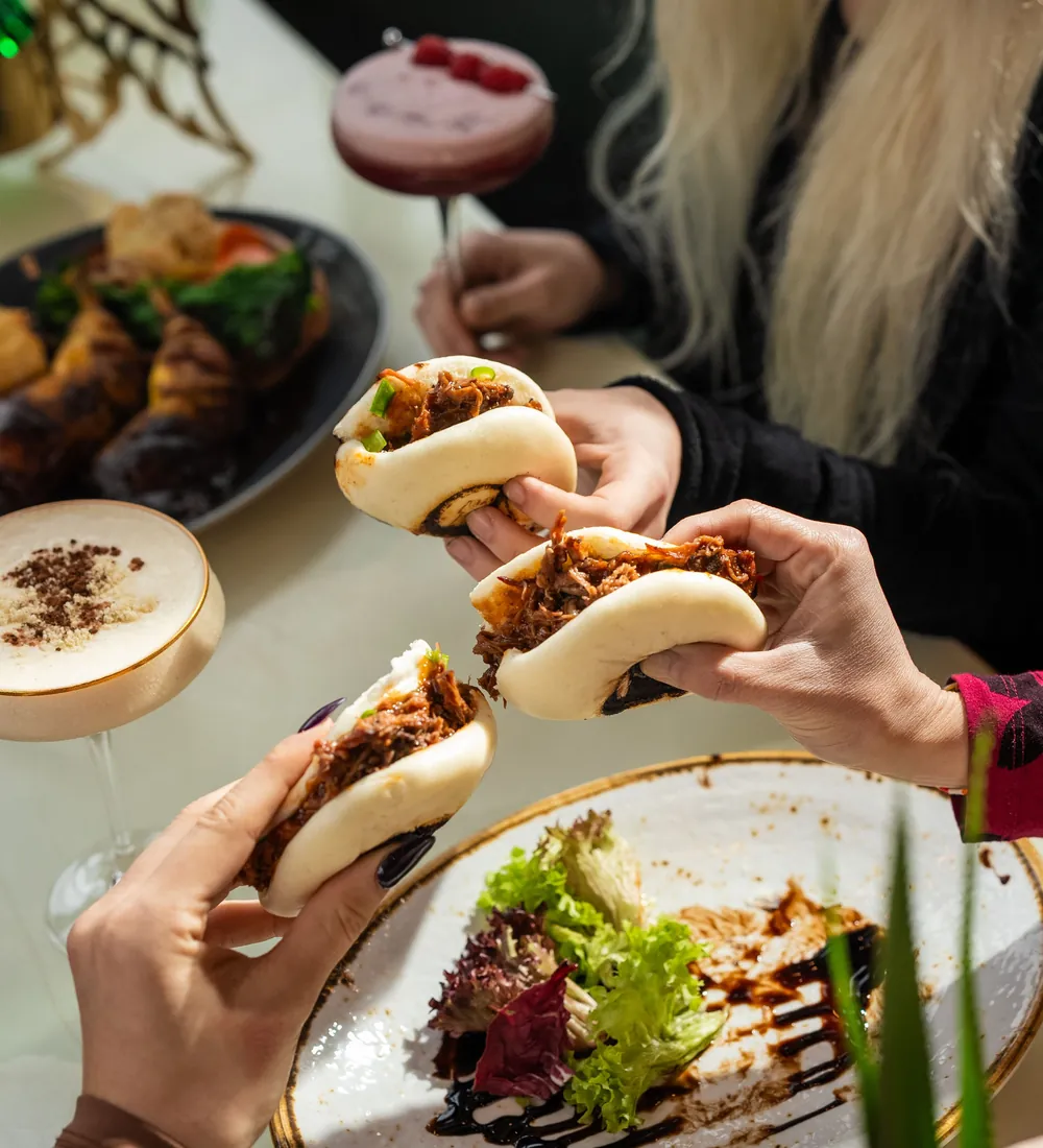 Friends sharing bao buns at dinner