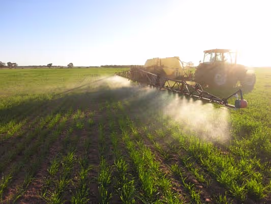 A boom spray spraying carbon boost onto a paddock 