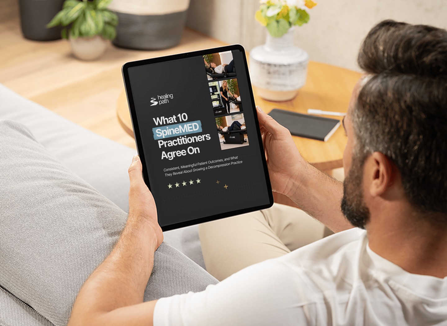 Practice owner reading the SpineMED white paper "What 10 SpineMED Practitioners Agree On" on a tablet