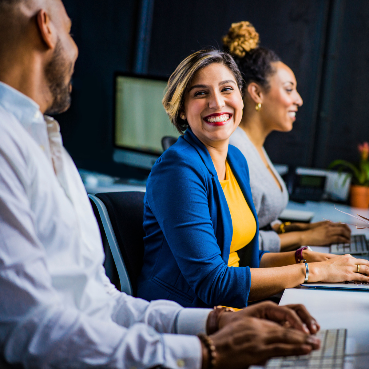 Mortgage professionals smiling while using mlo software on their computers