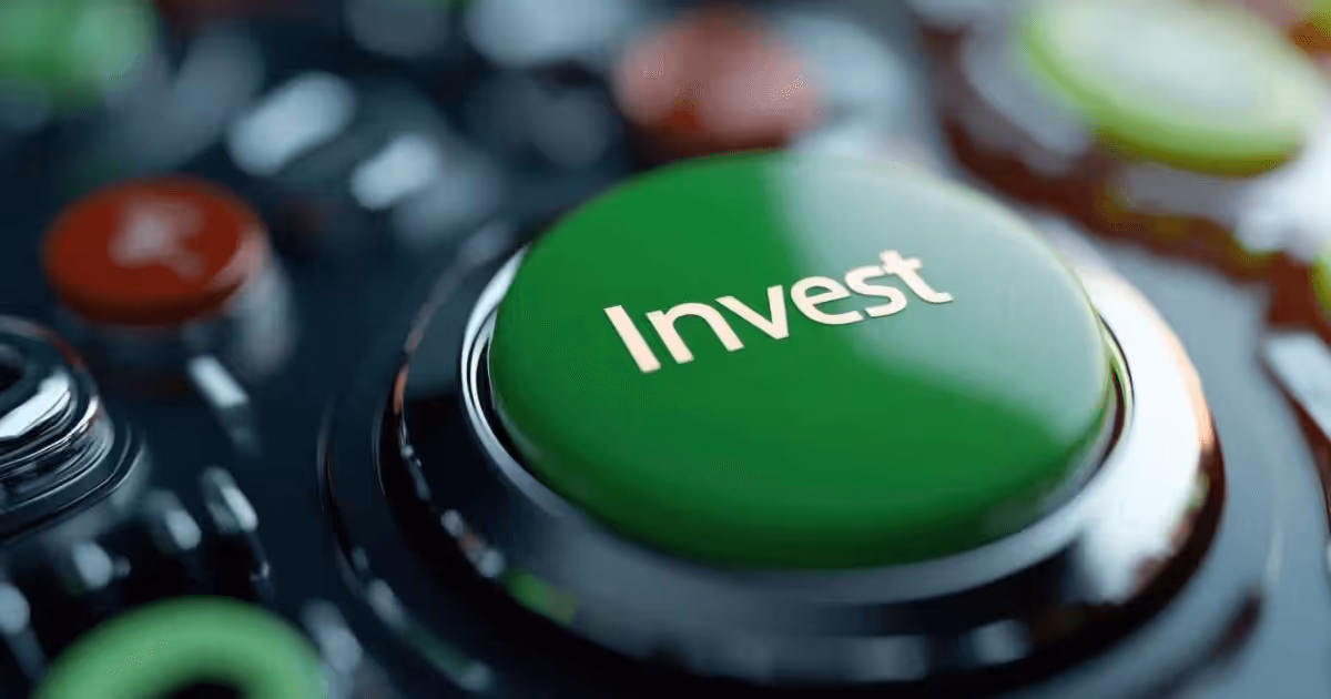 Close-up of a green button labeled Invest' in white text, surrounded by other blurred buttons on a control panel, symbolizing financial decision-making and investment actions