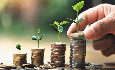 Close-up of coins stacked in rows with small plants growing from each pile, illustrating the concept of saving and wealth accumulation.