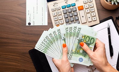 Holding euro banknotes beside a calculator illustrating new lifetime allowance rules