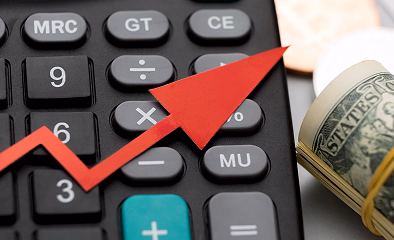 Calculator with an upward arrow and rolled banknotes illustrating low cost QROPS options