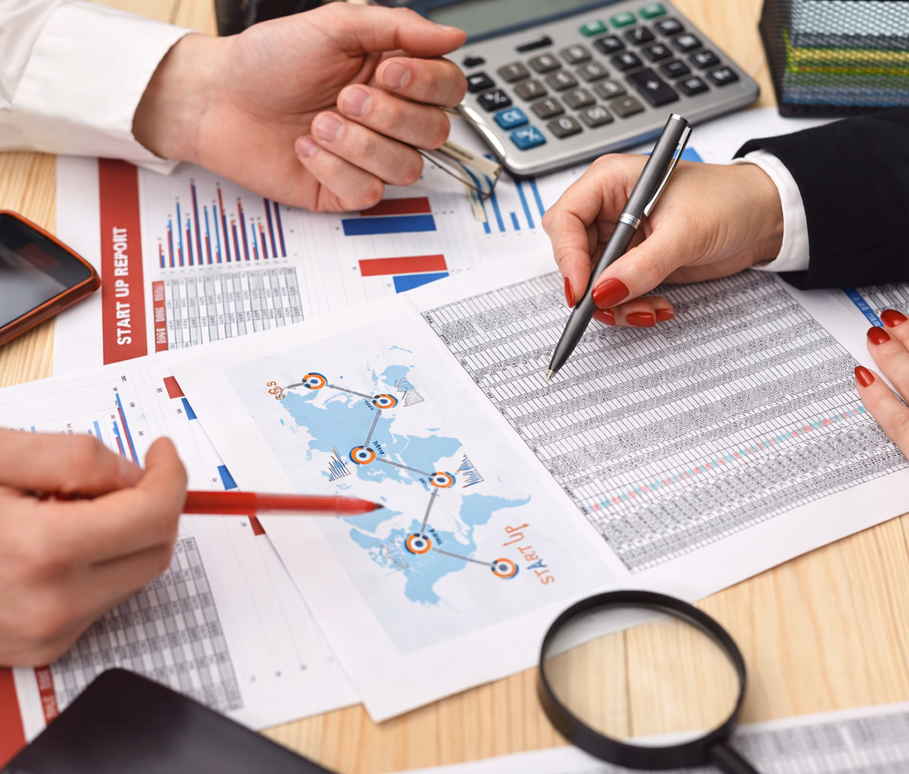 Two professionals review financial reports and global data during finance planning session.