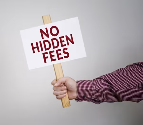 A person holding a sign that says “No Hidden Fees” in bold red letters against a plain background.