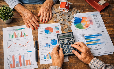 Top-down illustration of a retired couple using a calculator, counting coins, and going over financial charts and documents at a wooden table to symbolize retirement financial planning and strategy.