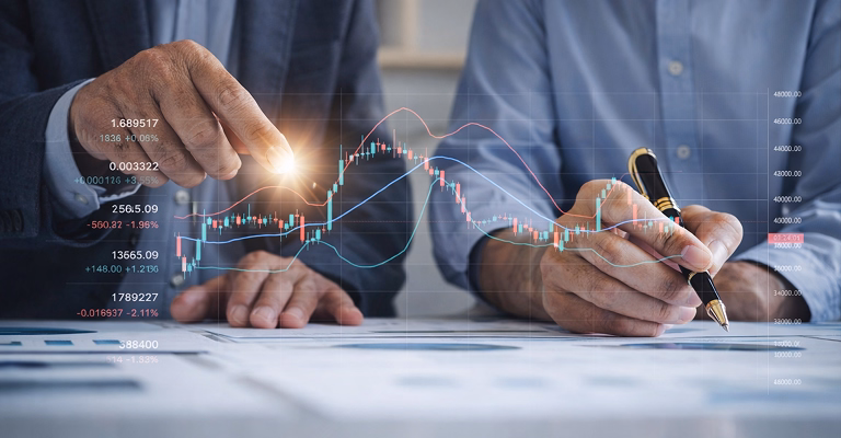 Two professionals analyzing financial charts and market data, discussing investment strategy and portfolio performance