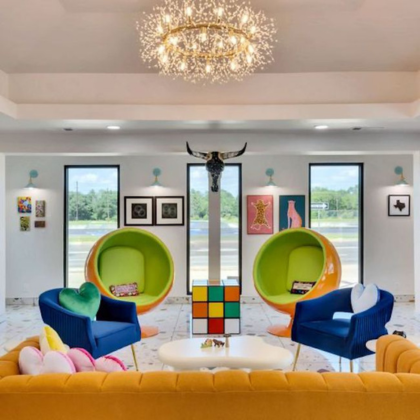 Playful hotel lobby with colorful chairs, unique decor, and a large chandelier at Hotel McCoy.