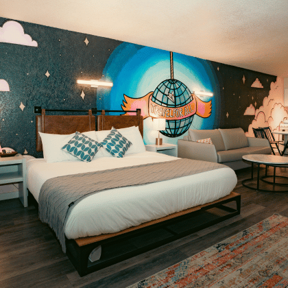 La espaciosa suite de diseño abierto cuenta con una cama grande y cómoda, una acogedora zona de estar con sofá y una práctica cocina americana.