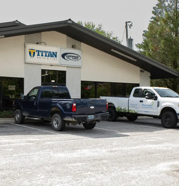 Two pick up trucks parked in front of a garage