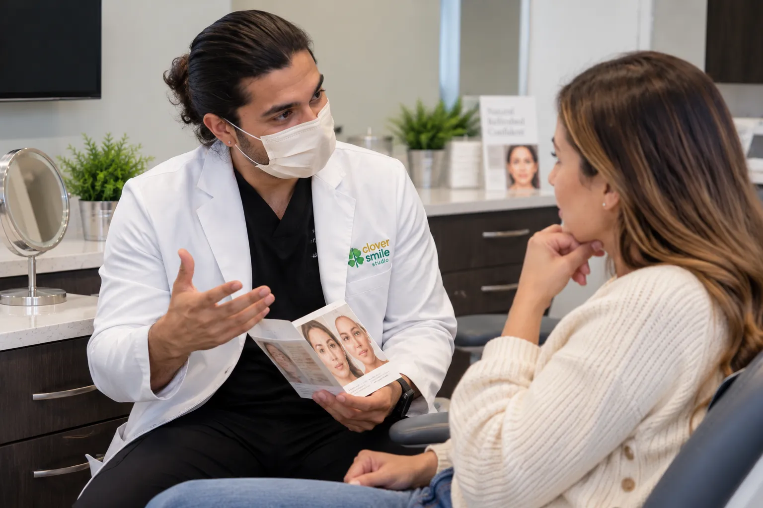 Dentist wearing a face mask explaining facial esthetic treatment options and answering a female patient's questions during a consultation at Clover Smile Studio.