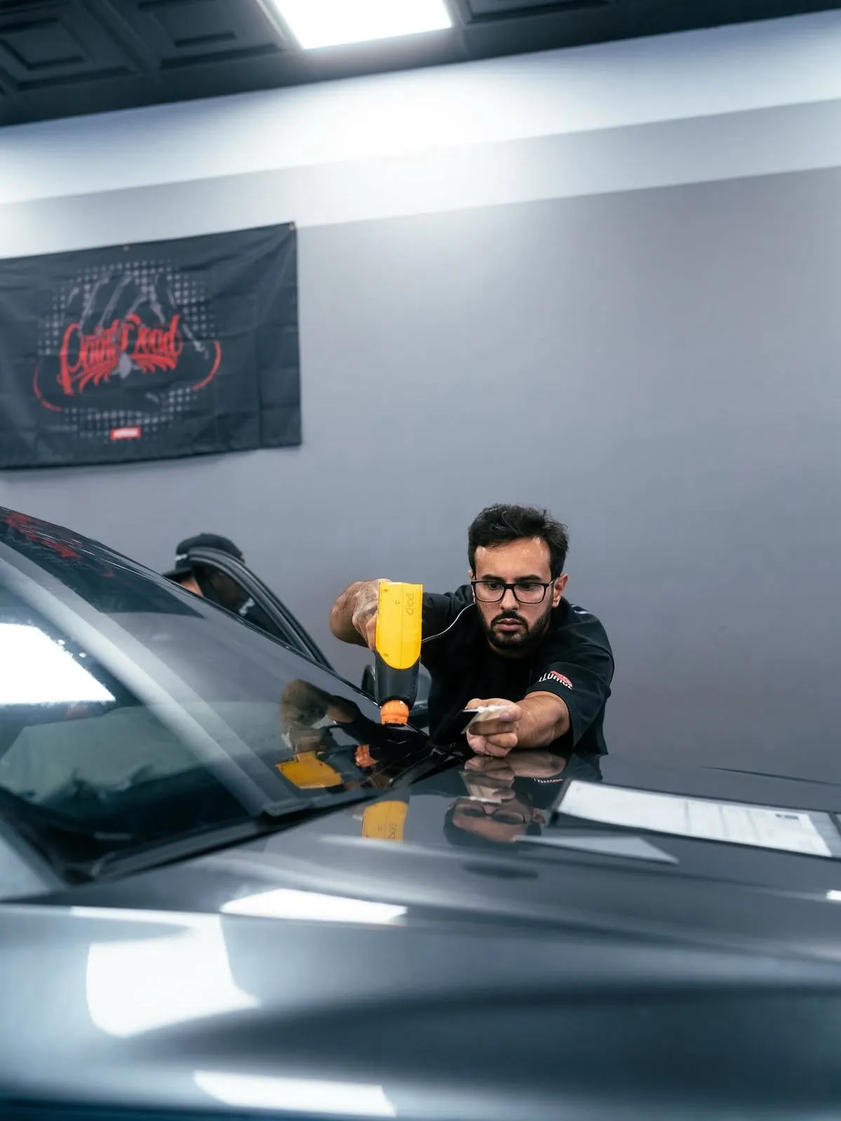 Allure Auto Spa installer heat-shaping window tint film on a car windshield, Winter Park FL