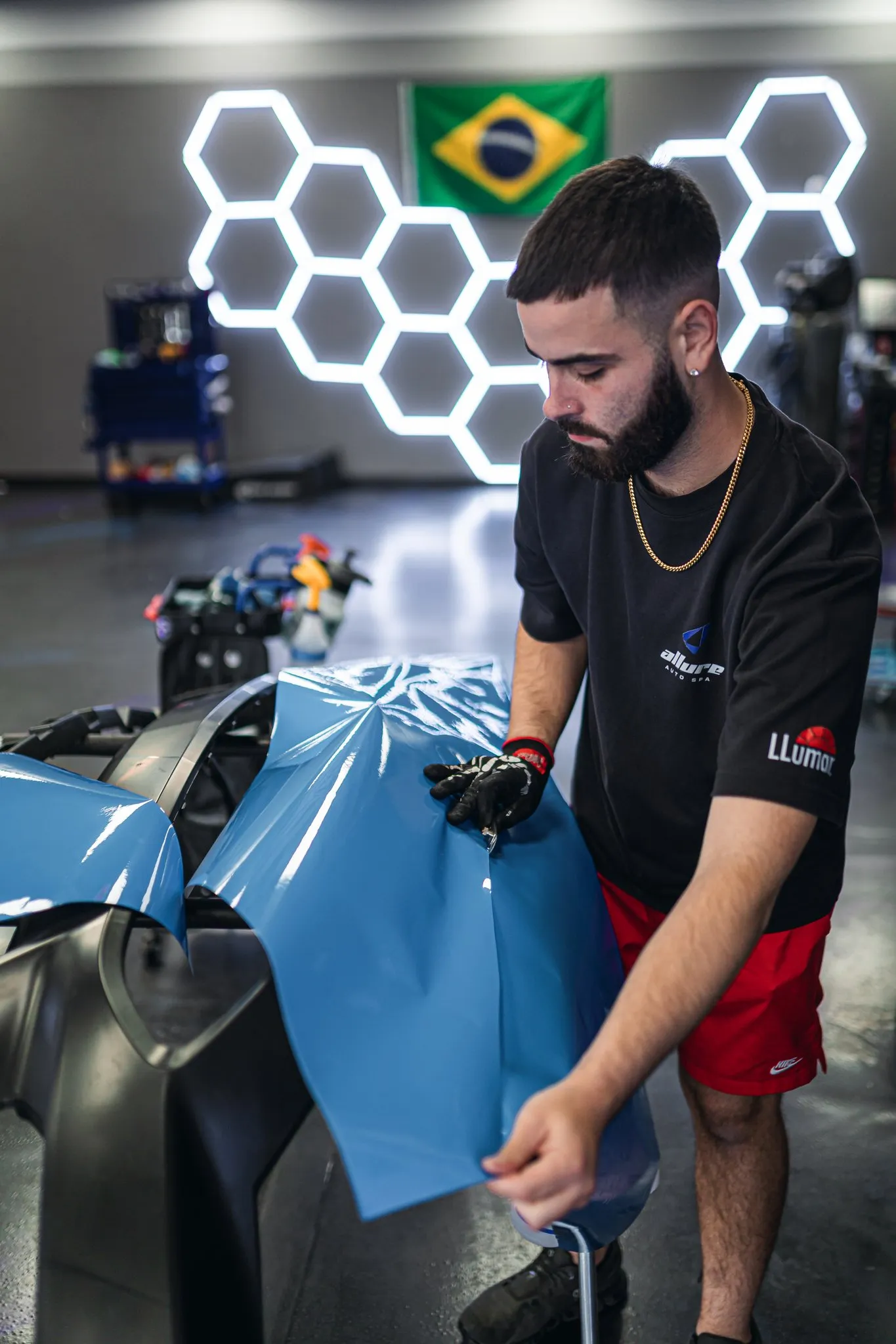 Blue vinyl color-change wrap being installed at Allure Auto Spa, Winter Park FL
