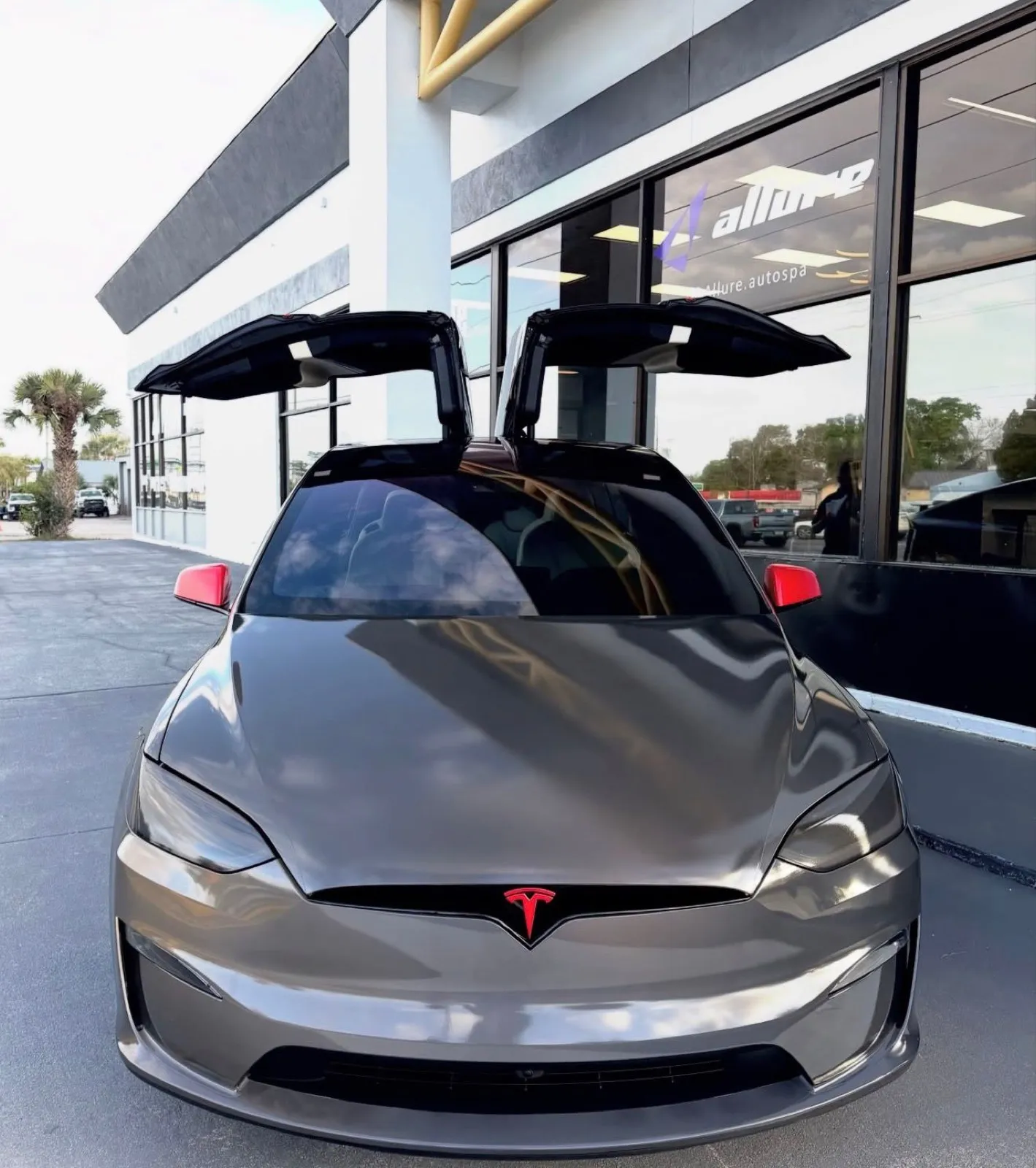 Tesla Model X in a full black reflective vinyl wrap with red accents at Allure Auto Spa, Winter Park FL