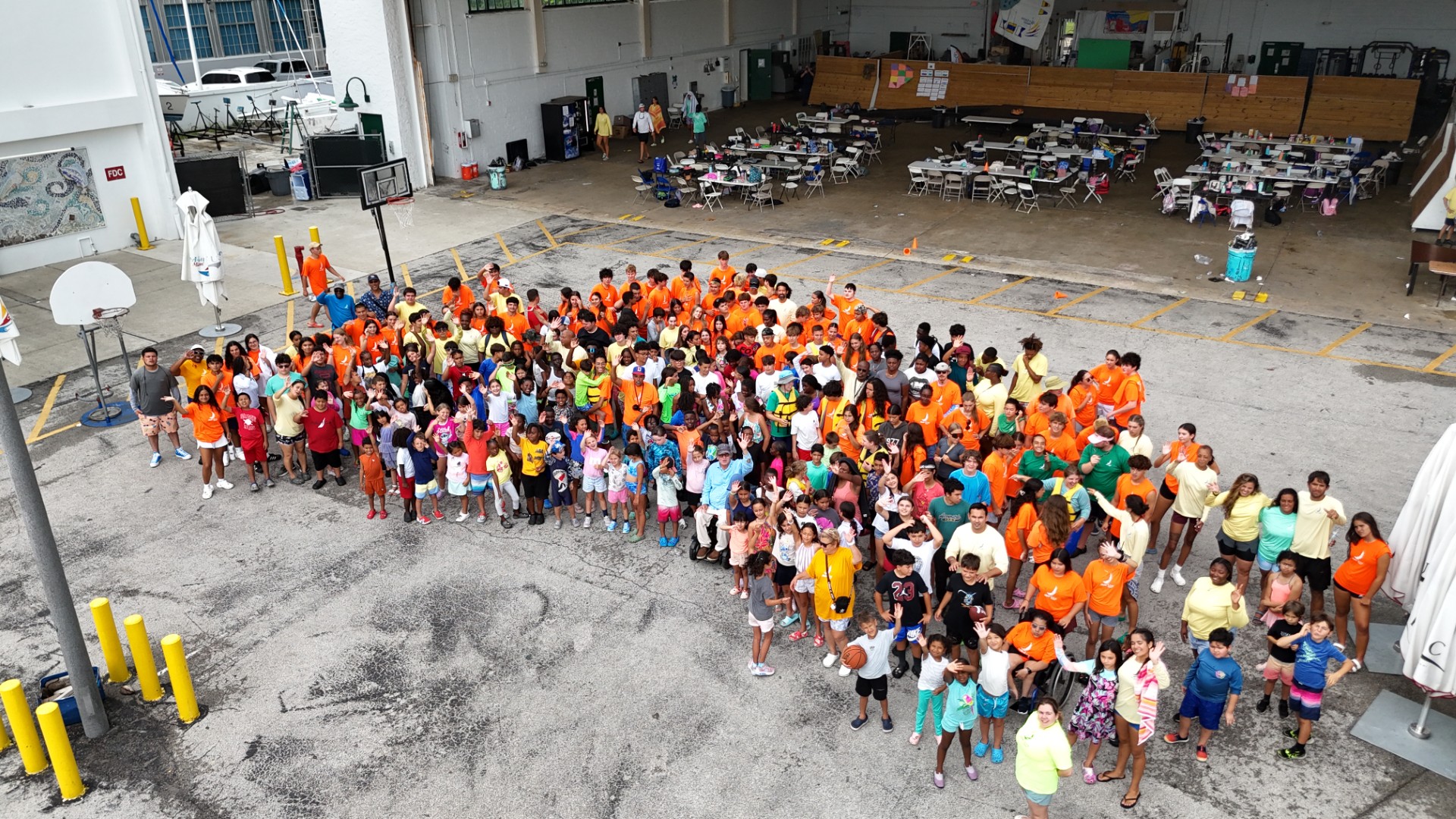 Campers and staff in orange shirts gathered outside the Shake-A-Leg Miami warehouse