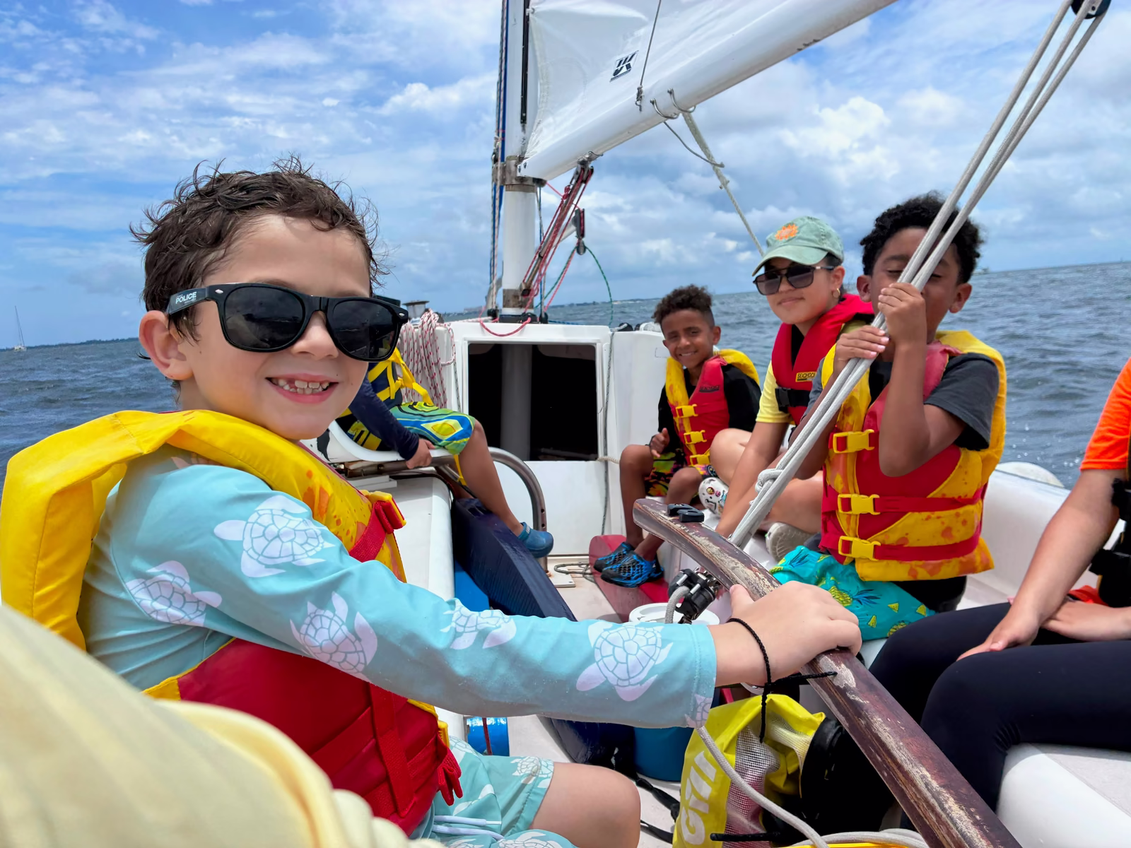 Camper in sunglasses aboard sailboat