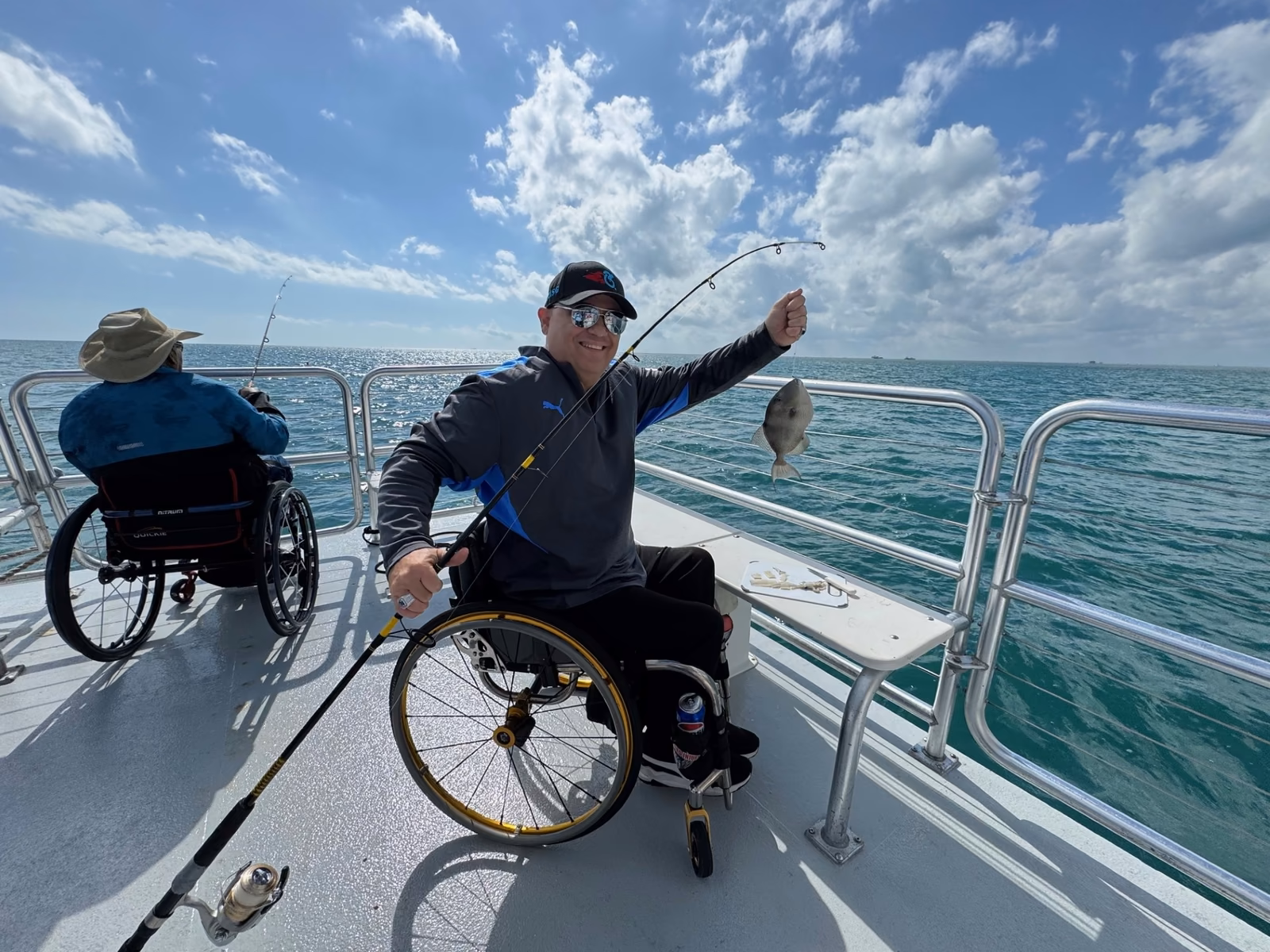 Angler in wheelchair holding fish
