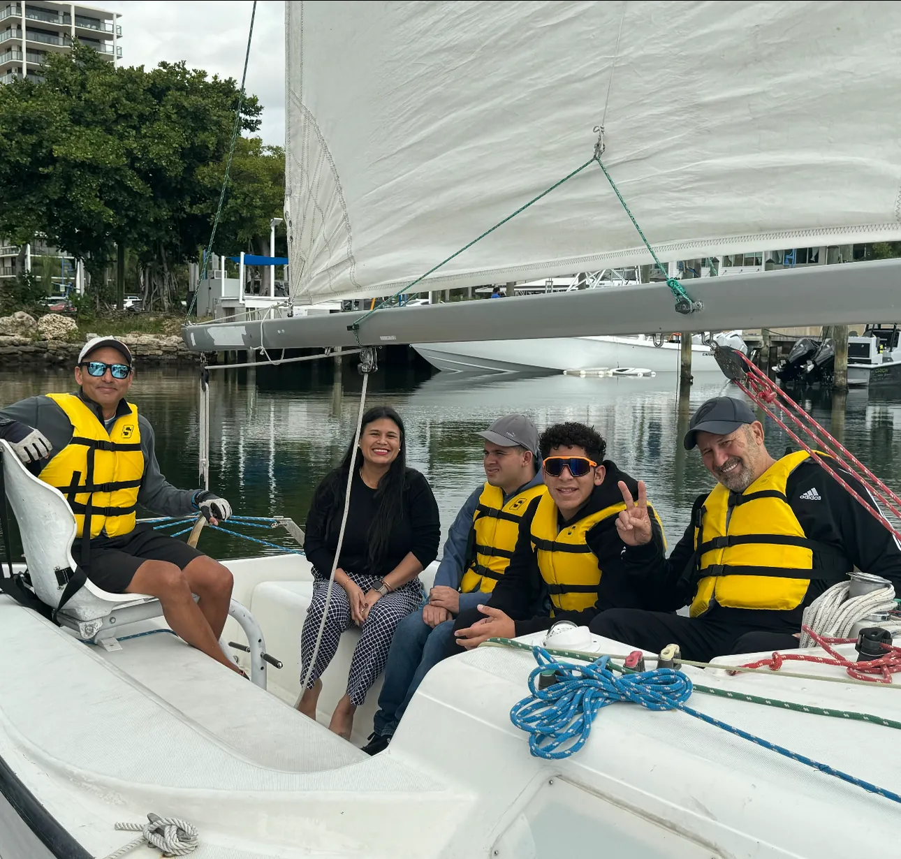 Students in life vests sitting together in the cockpit of a sailboat