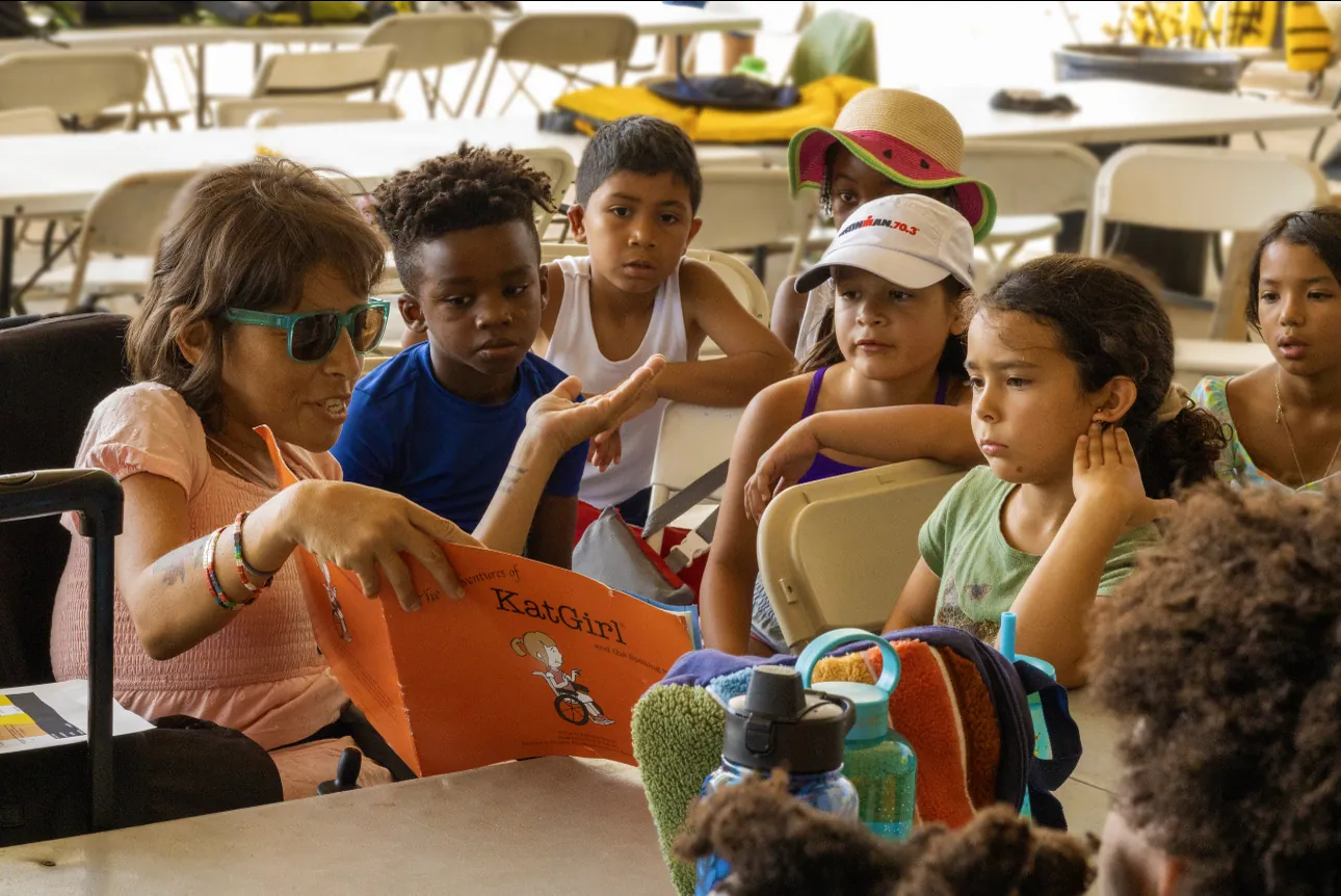 Campers reading and drawing together at a table