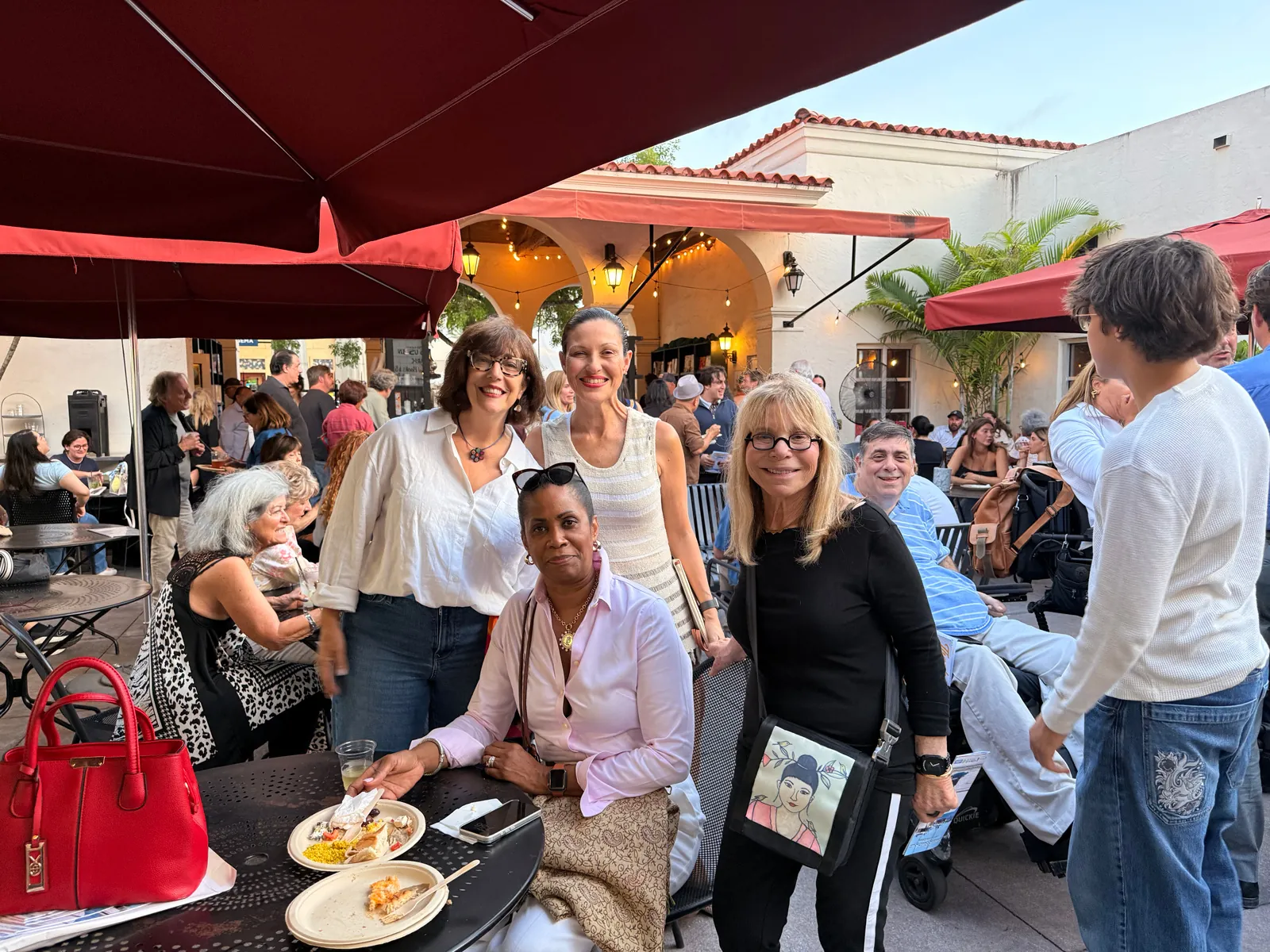 Guests gathered at outdoor tables under red umbrellas during a Shake-A-Leg Miami reception