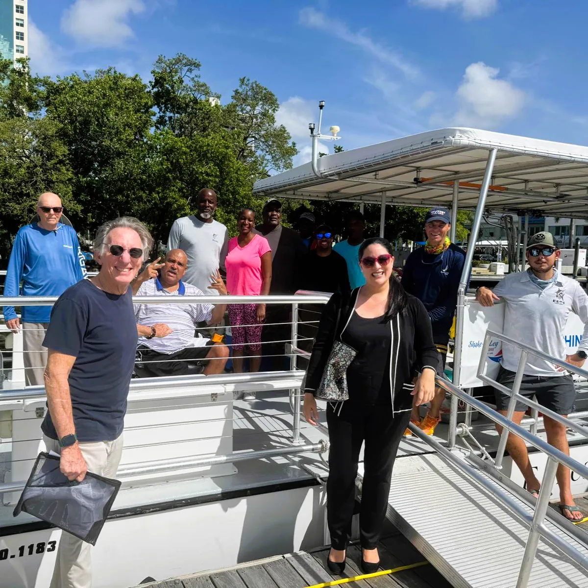 Volunteers gathered on the dock beside an accessible pontoon boat