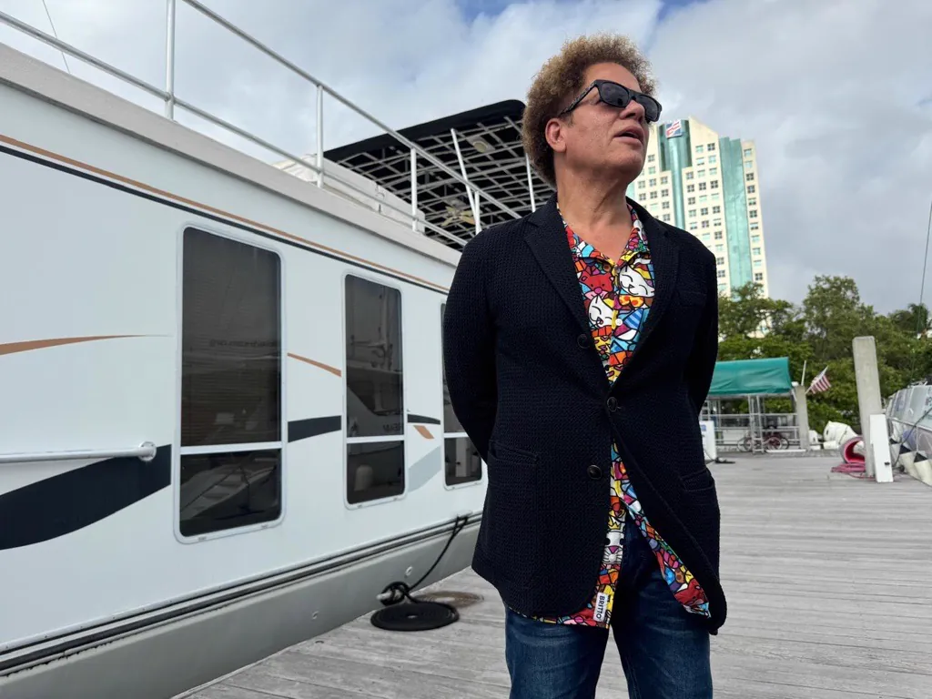 Romero Britto standing beside the houseboat he painted