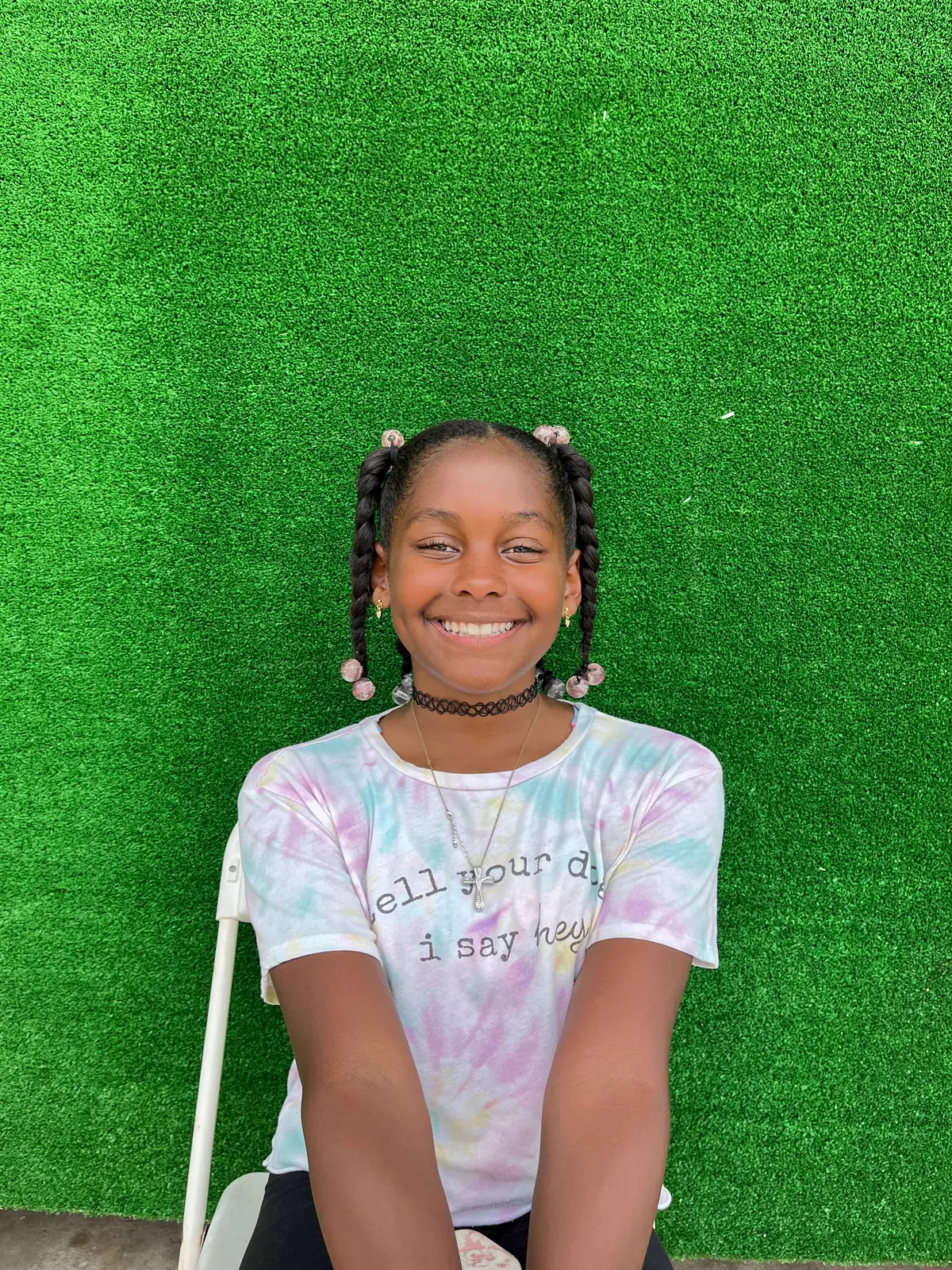 A young camper lying on the grass and smiling up at the camera