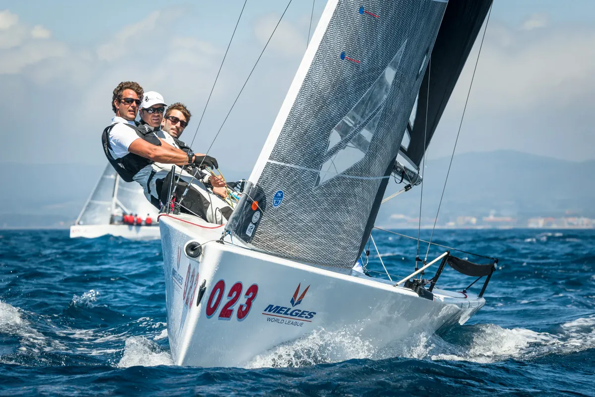 A keelboat crew hiking out hard as the boat powers upwind