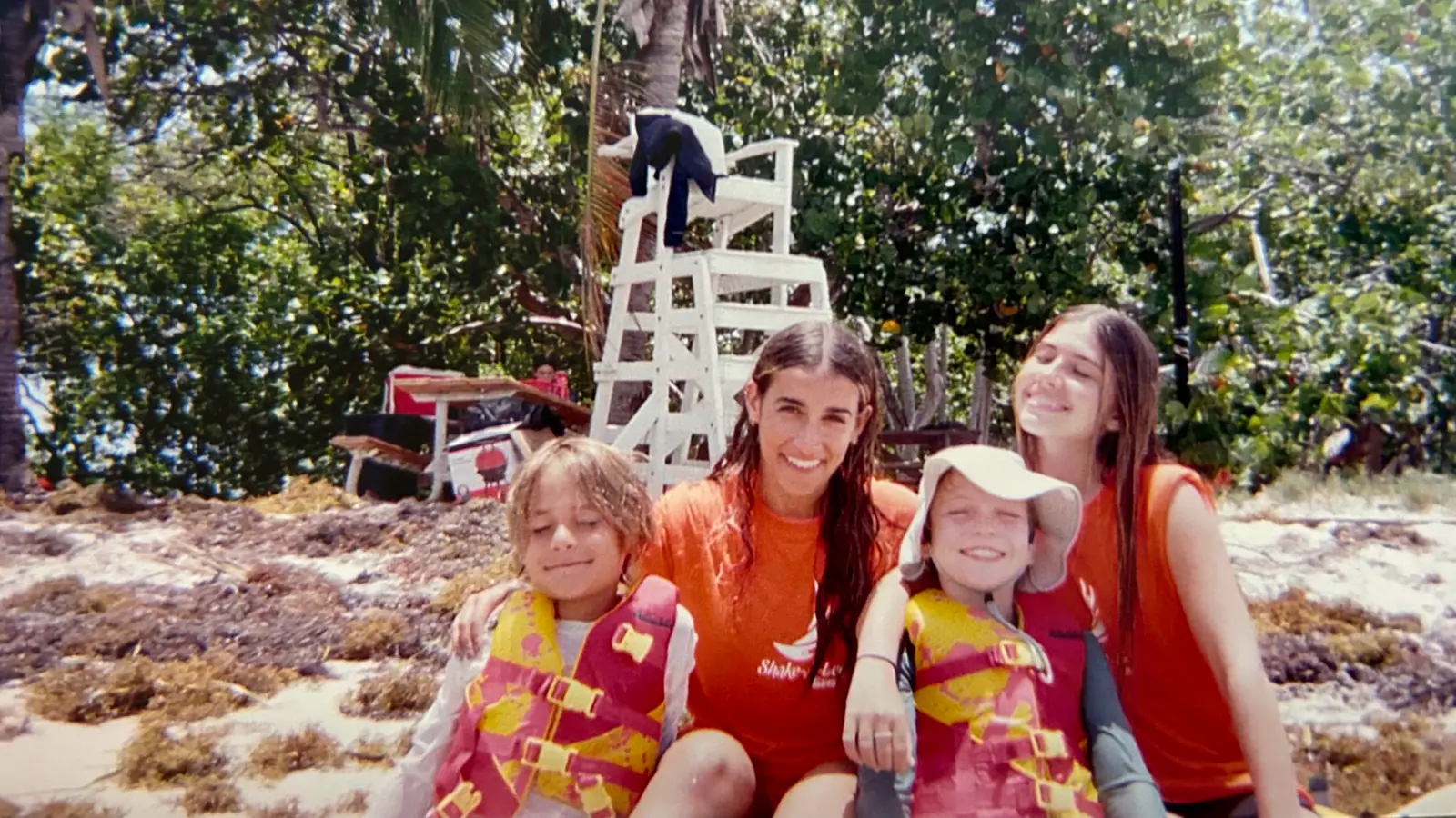 Campers and a staff member sitting together by the mangroves