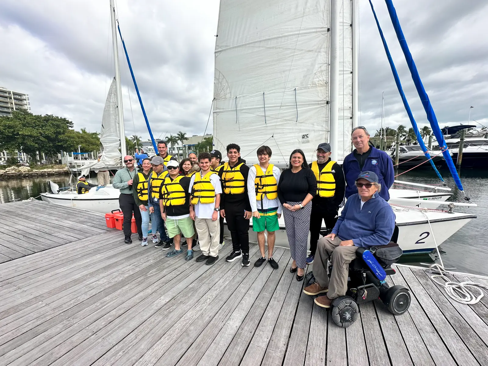 Participants in life vests seated together under a boat's canopy