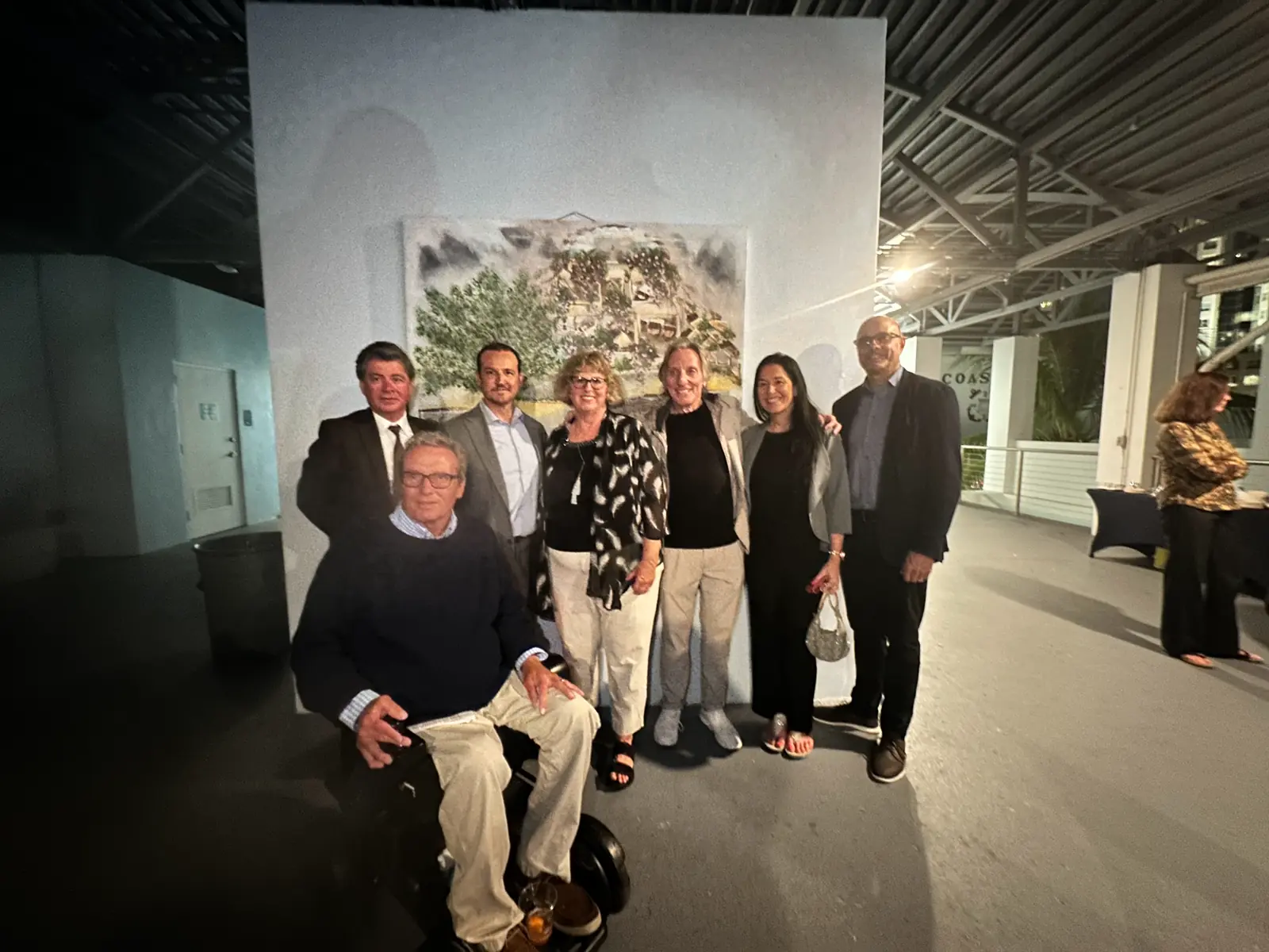Guests at an indoor reception holding a framed presentation
