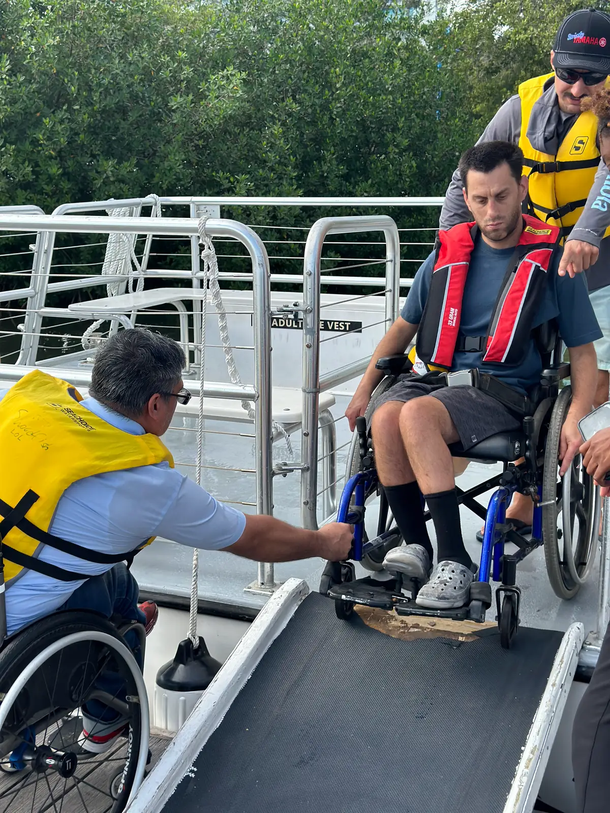 A participant being lifted aboard by the boat's accessible hoist