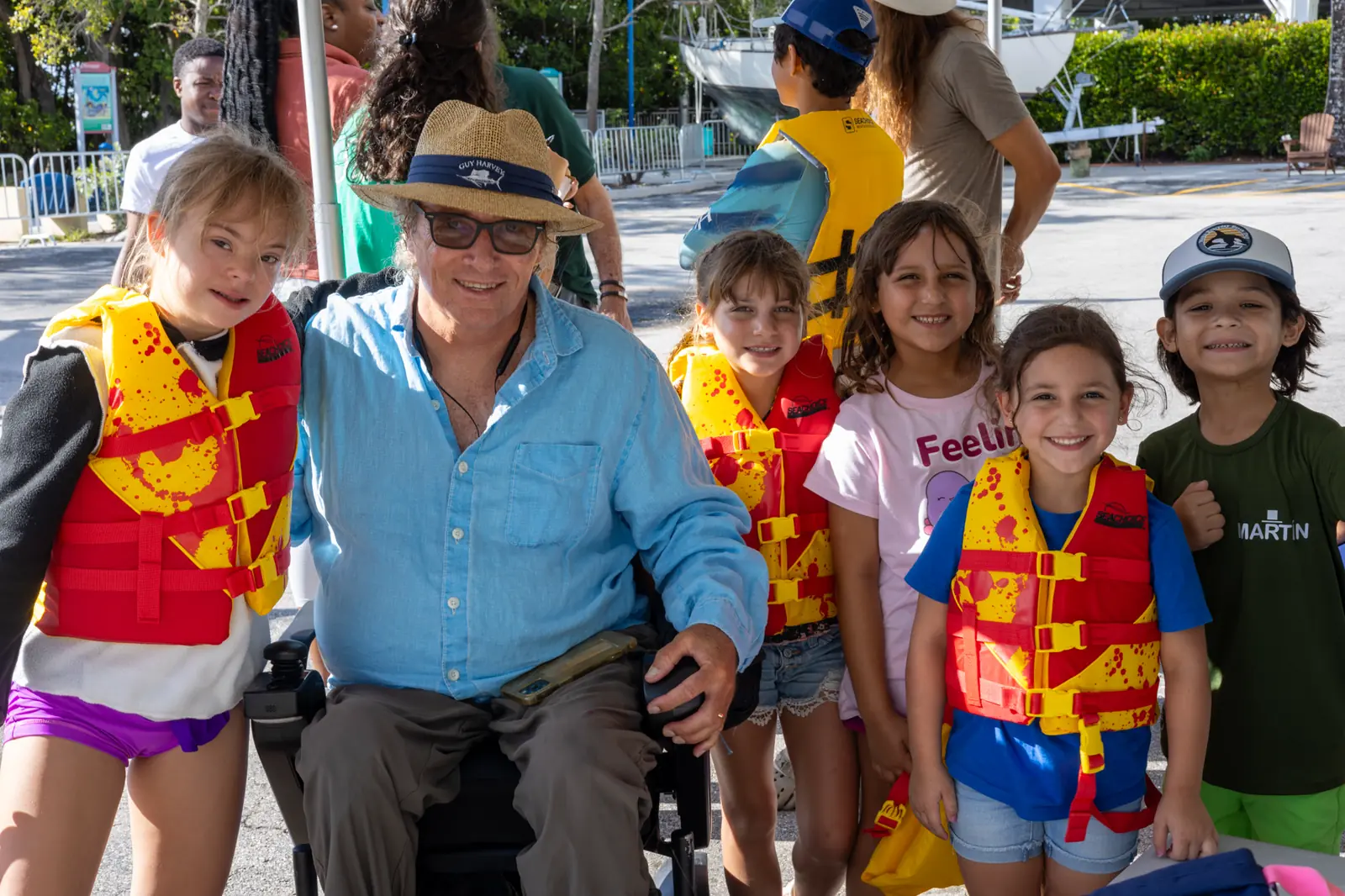 A volunteer surrounded by campers in life vests at the waterfront