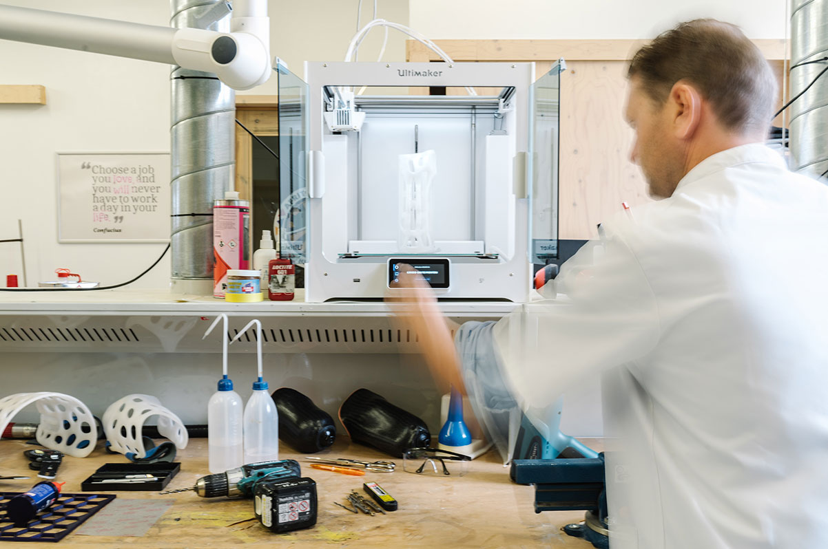 Technician preparing a 3D printer to produce custom orthotic molds