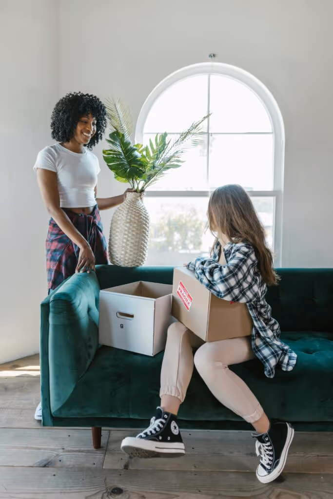 two adults talking in a living room while unpacking 