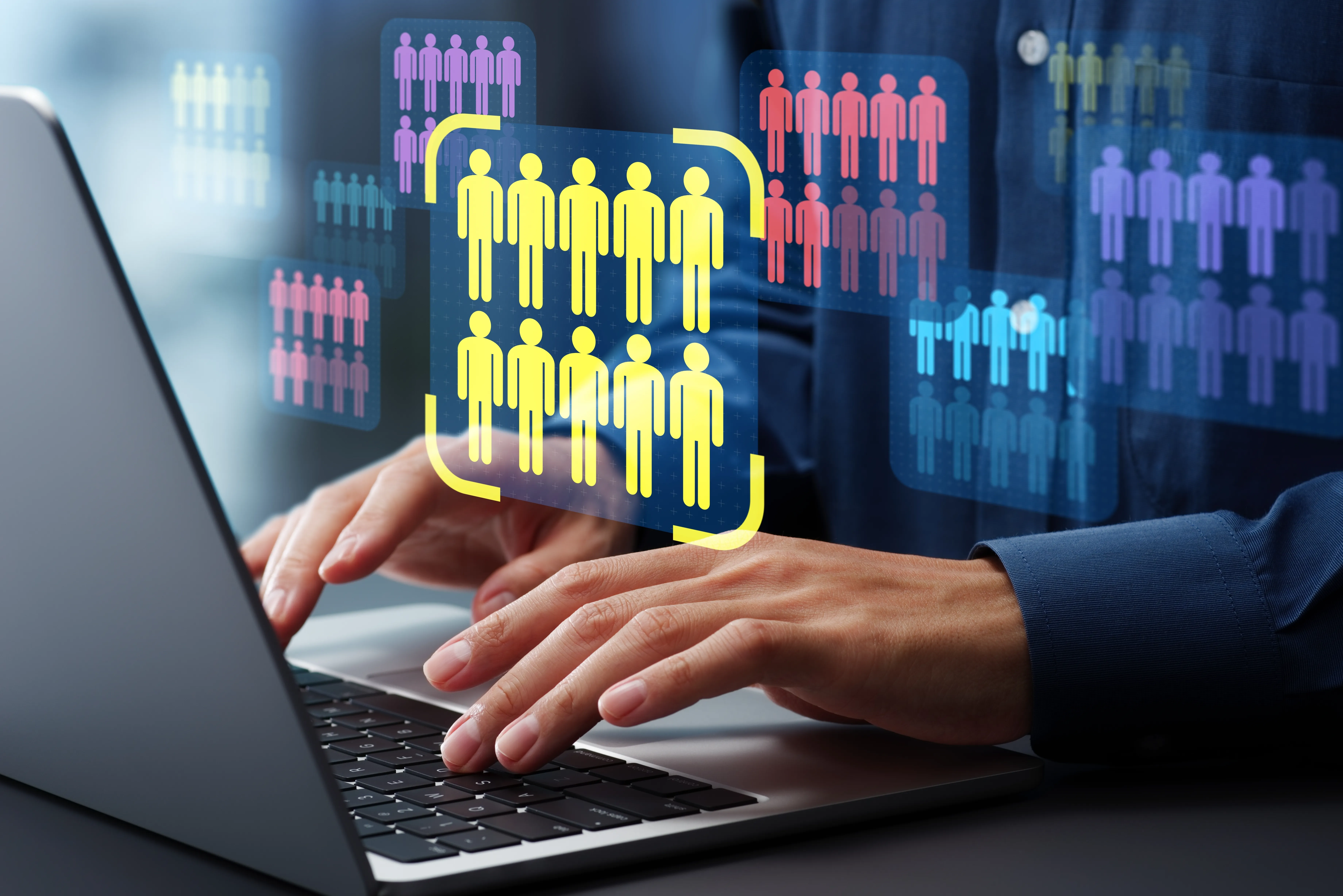 Hands typing on a laptop as color-coded audience segments float above, with one yellow group highlighted for targeting