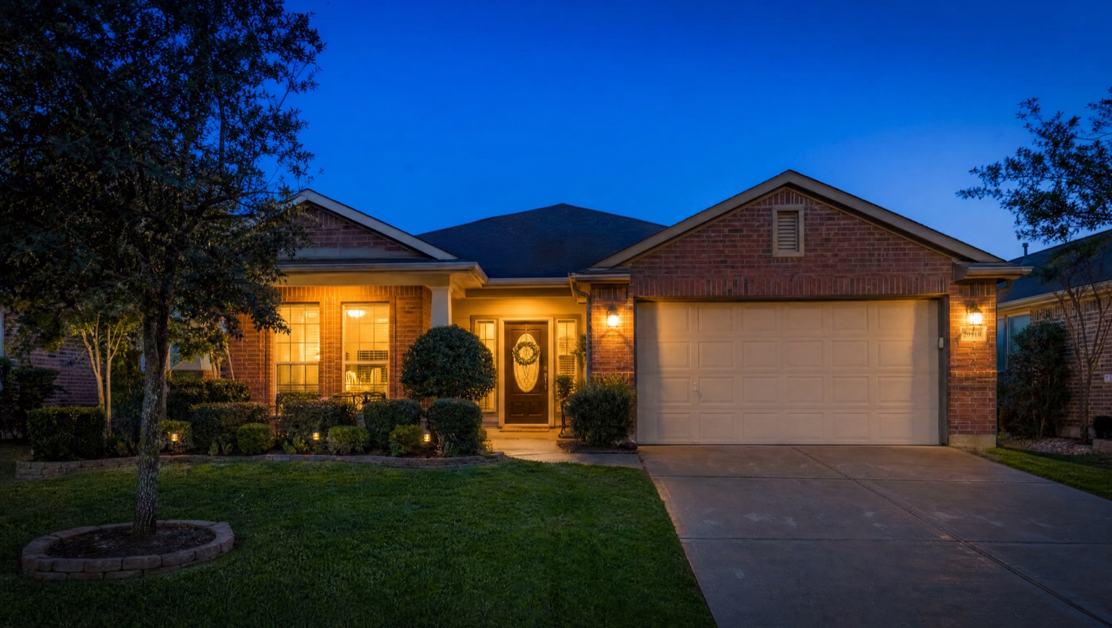 Texas home at dusk with warm lights in the windows