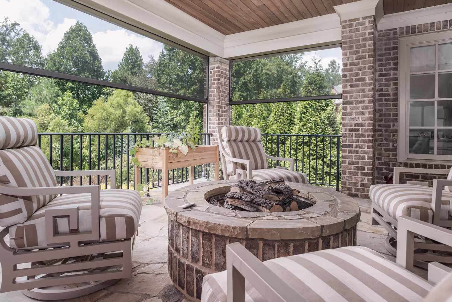 An outside fireplace with retractable screens installed.