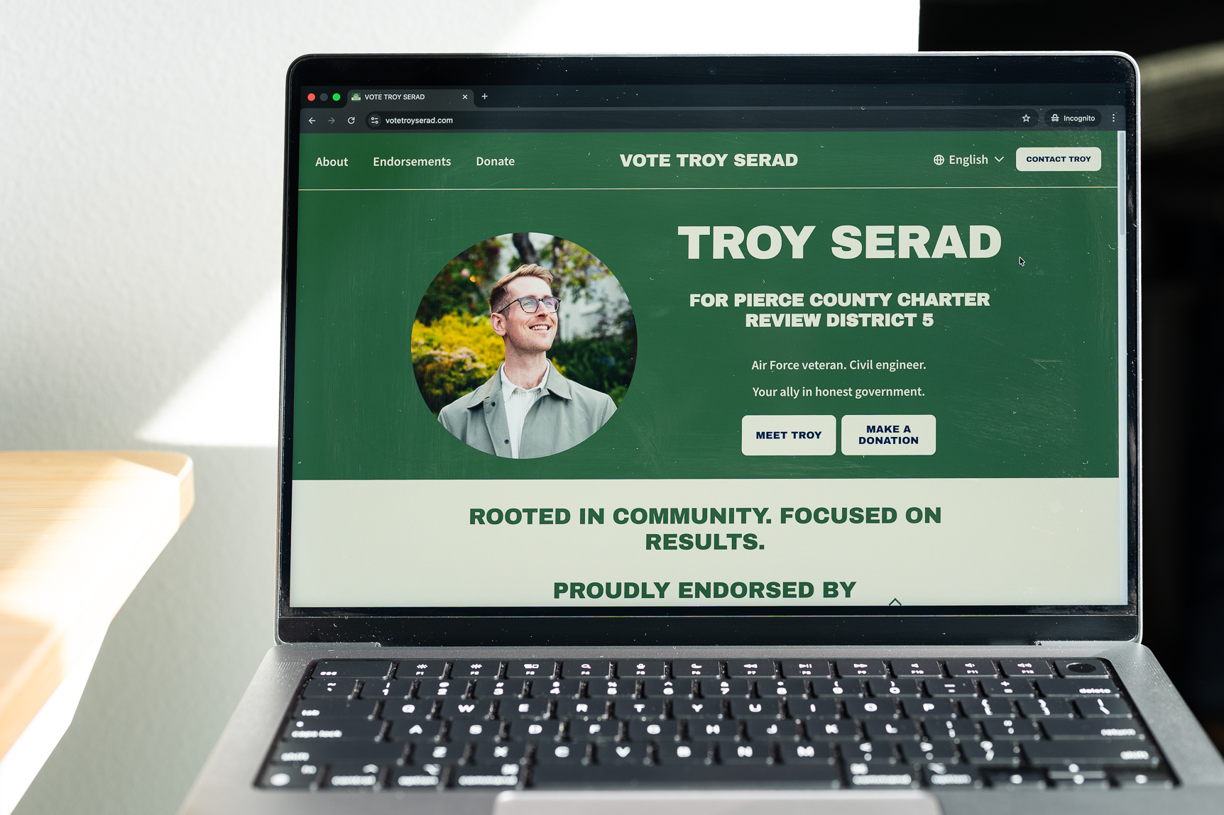 A laptop shows a website designed by Kevin.